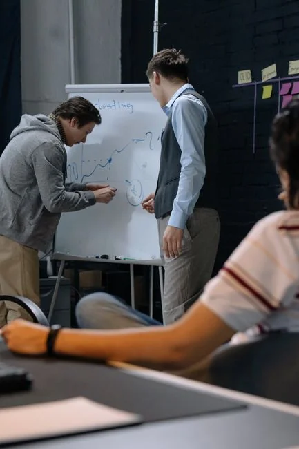 Un espace de travail moderne où des mains analysent des données marketing sur un ordinateur portable et des documents papier.